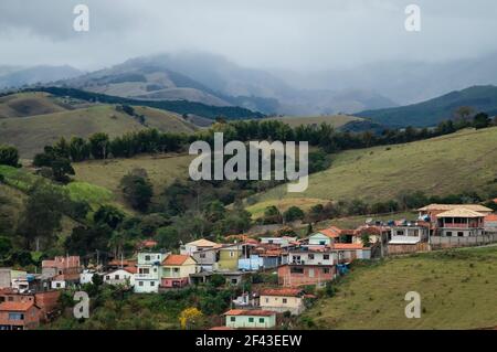 Nordostansicht der bergigen Landschaft und Wohngebiet der Gemeinde Cunha am frühen Morgen mit Wolken über den Bergen. Stockfoto