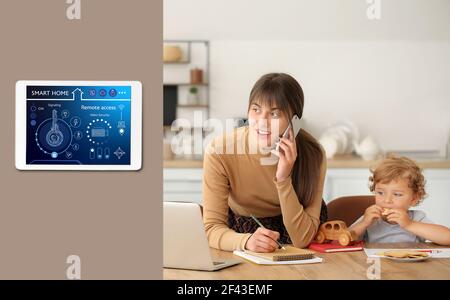 Junge Mutter mit kleinen Sohn in der Küche unter Schutz der Smart Home Sicherheitssystem Stockfoto