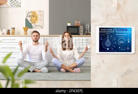 Junges Paar meditiert in der Küche unter dem Schutz der Smart Home Sicherheitssystem Stockfoto