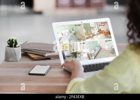 Frau mit Laptop Blick auf die Bilder von cctv-Kameras Installiert in der Wohnung Stockfoto
