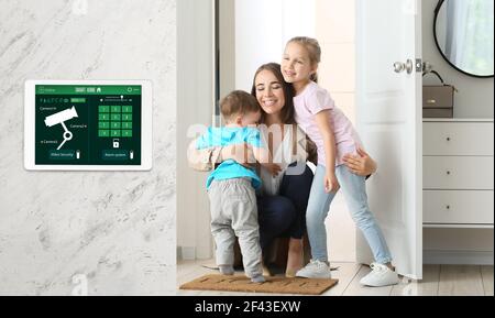 Glückliche Kinder und ihre Mutter in der Halle unter dem Schutz der Smart Home Sicherheitssystem Stockfoto