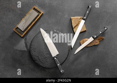 Messerset mit Schleifsteinen auf dunklem Hintergrund Stockfoto