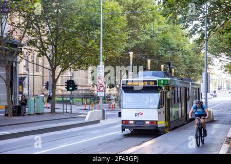 Melbourne Straßenbahn und Mann Fahrrad auf Swanston Street in Melbourne City Centre, Australien Stockfoto