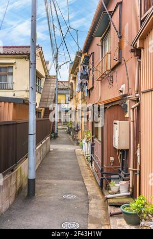 tokio, japan - oktober 11 2020: Schmale Straße eines ländlichen Stadtteils der Innenstadt von sumida mit typischen japanischen Häusern in rostigen Wellblechen und Stockfoto