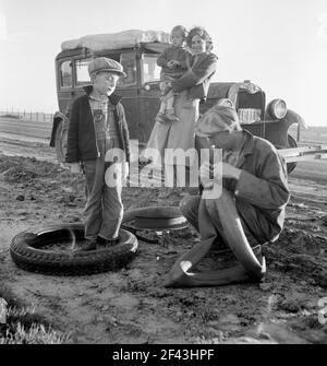 Wandernde landwirtschaftliche Arbeiterfamilie mit zusammengebrochenem Auto entlang California Highway. USA 99. März 1937. Foto von Dorothea lange. Stockfoto