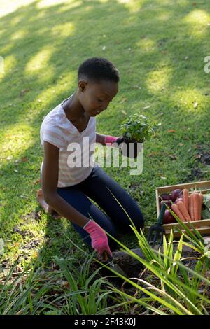 afroamerikanische Frau im Garten auf der sonnigen Gartenterrasse Stockfoto