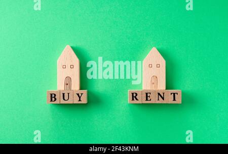 Kaufen oder mieten Wohnbild mit Spielzeughäusern aus Holz auf einem grünen Hintergrund platziert Stockfoto