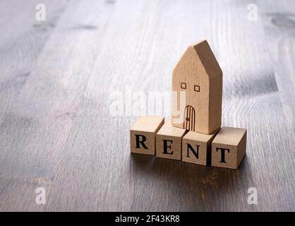 Spielzeughaus aus Holz und MIETE Blöcke auf gesetzt Ein Holzhintergrund Stockfoto