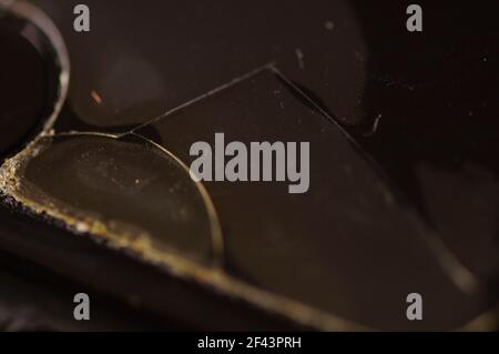 Smartphone-Schutzglas – beschädigt, gerissen, abgenutzt. Alter Bildschirmschutz. Schmutziges, schwarzes, abgenutztes Telefon. Stockfoto