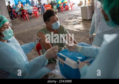 Bangkok, Thailand. März 2021, 18th. Ein Gesundheitshelfer, der kurz vor der Impfung eines Mannes mit dem Coronavac (Sinovac)-Impfstoff auf dem Bang Khae-Markt steht, während eines Massenimpfungsprogramms in Bangkok, Thailand, am 18. März 2021. Die Bangkok Metropolitan Administration (BMA) startete ein Massenimpfungsprogramm im geschlossenen Bang Khae Markt, nachdem 224 Fälle von Covid-19 unter den Bewohnern in und um den Markt gefunden wurden. Insgesamt 6000 Dosen werden für die nächsten Tage verabreicht werden, sagte der Gouverneur. (Foto: Guillaume Payen/SOPA Images/Sipa USA) Quelle: SIPA USA/Alamy Live News Stockfoto