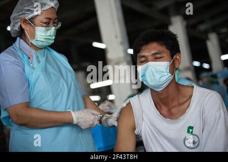 Bangkok, Thailand. März 2021, 18th. Ein Gesundheitshelfer impft am 18. März 2021 im Rahmen eines Massenimpfungsprogramms in Bangkok, Thailand, einen Mann mit dem Coronavac (Sinovac)-Impfstoff auf dem Bang Khae-Markt ein. Die Bangkok Metropolitan Administration (BMA) startete ein Massenimpfungsprogramm im geschlossenen Bang Khae Markt, nachdem 224 Fälle von Covid-19 unter den Bewohnern in und um den Markt gefunden wurden. Insgesamt 6000 Dosen werden für die nächsten Tage verabreicht werden, sagte der Gouverneur. (Foto: Guillaume Payen/SOPA Images/Sipa USA) Quelle: SIPA USA/Alamy Live News Stockfoto