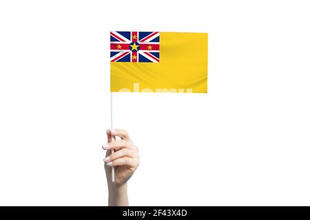 Schöne weibliche Hand hält Niue Flagge, isoliert auf weißem Hintergrund. Stockfoto