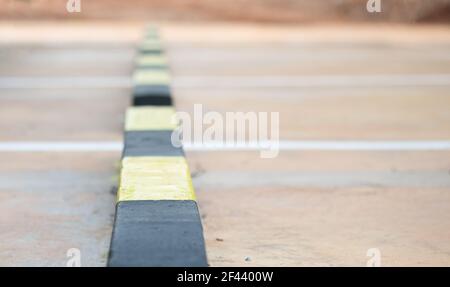 Reihe von Beton Radstopper in schwarz und gelb gestreift mit selektiven weichen Fokus. Stockfoto