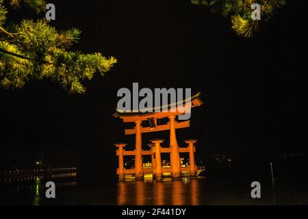 Nachtaufnahme des Bootes am schwimmenden Torii-Tor am Itsukushima Shinto-Schrein auf der Insel Itsukushima (Miyajima), Japan Stockfoto