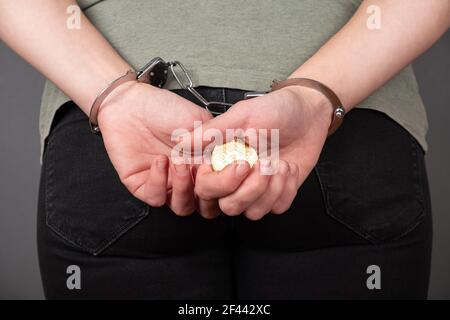 Mann in Handschellen mit einer Goldmünze Stockfoto