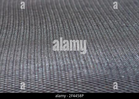 Schwarze synthetische Textil Möbel Polstergewebe. Hintergrund mit Löchern strukturiert Nahtloses Muster. Stockfoto