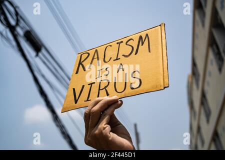Ein Mann hält Rassismus ist ein Virus-Zeichen Stockfoto