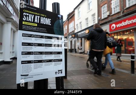 Datei Foto vom 06/01/21 von Menschen, die ein Regierungsschild mit der Aufschrift "Stay at Home" passieren. Seit Beginn der Pandemie hat die Regierung die Botschaft verbreitet, wie die Ausbreitung von Covid-19 durch den Einsatz von knappen Slogans und im Fernsehen übertragenen Briefings bekämpft werden kann, doch Experten glauben, dass einige der Botschaften nicht immer klar und konsistent waren. Ausgabedatum: Freitag, 19. März 2021. Stockfoto