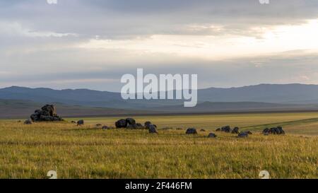 Steinformationen in der Nähe von Orkhon und Jargalant in der Mongolei in der Steppe bei Sonnenuntergang am Abend. Stockfoto