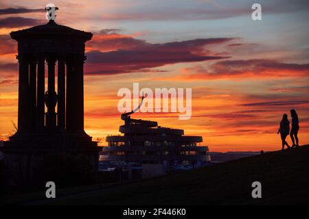 Das Dugald Stewart Monument auf Calton Hill und das neue W Hotel in Edinburghs St James Quarter Entwicklung bei Sonnenuntergang. Bilddatum: Donnerstag, 18. März 2021. Stockfoto