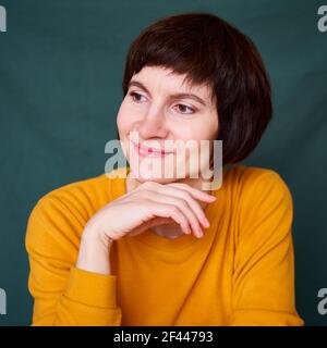 Lächelnd reife Brünette Frau wegschauen verspielt und trotzig, Nahaufnahme Gesicht Stockfoto