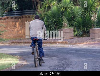 Johannesburg, Südafrika - nicht identifizierter schwarzer Mann fährt mit seinem Fahrrad zur Arbeit nach der Aufhebung der Covid-19-Beschränkungen Stockfoto