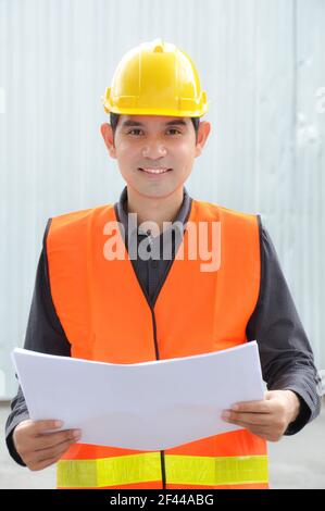 Asiatischer Ingenieur oder Vorarbeiter trägt Sicherheitsweste & Hut Stockfoto