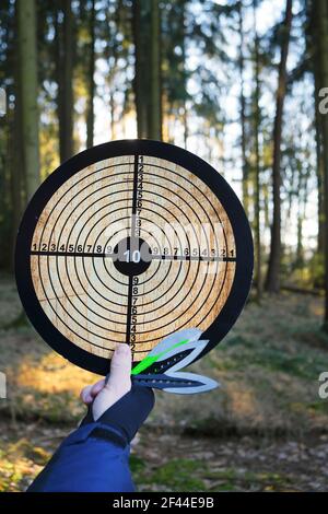 Wurfmesser. Sport und Hobby Konzept.Wurfmesser gesetzt und Ziel in der Hand auf verschwommenem Wald Hintergrund.Outdoor-Sport. Aktive Sportarten in der Stockfoto