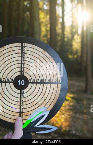 Wurfmesser. Sport und Hobby Konzept.Wurfmesser gesetzt und Ziel in der Hand auf verschwommenem Wald Hintergrund.Outdoor-Sport. Aktive Sportarten in der Stockfoto