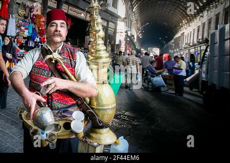 Menschen in Souq Al-Hamidiyah, dem wichtigsten Souk der Altstadt, Saftverkäufer im Al-Hamidiyeh Souk in Damaskus Stockfoto