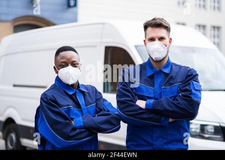 Elektriker Techniker Oder Klempner In Arbeitskleidung Und Gesichtsmaske In Der Nähe Van Stockfoto