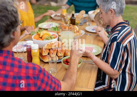 Kaukasische drei-Generationen-Familie hält Hände sagen Gnade vor dem Essen Gemeinsames Essen im Garten Stockfoto