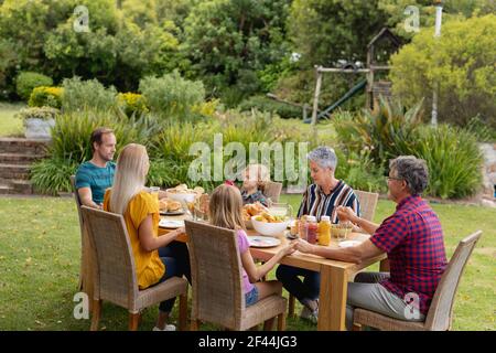 Kaukasische drei-Generationen-Familie hält Hände sagen Gnade vor dem Essen Gemeinsames Essen im Garten Stockfoto