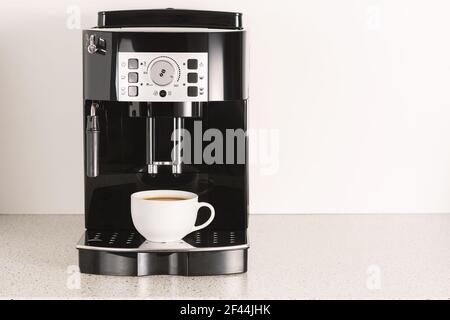 Moderne Espressomaschine mit einer Tasse in der Küche. Stockfoto