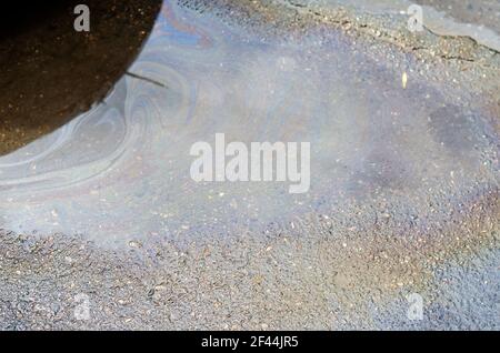 Strom von Regenwasser und Ölprodukten auf dem Asphalt. Abfälle aus der Ölindustrie fließen mit Regenwasser. Umweltprobleme, Umweltverschmutzung. Stockfoto