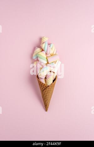 Bunte Marshmallows mit Eiscreme-Membran auf rosa Hintergrund. Kreatives, minimalistisches Urlaubskonzept. Stockfoto