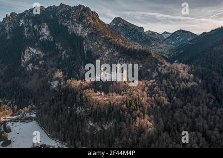 Luftdrohnenaufnahme des malerischen Schlosses Neuschwanstein auf einem verschneiten Hügel Im Winter Sonnenlicht in Deutschland Stockfoto