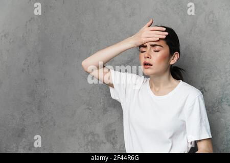Enttäuscht schöne junge Frau, die Hand an ihrer Stirn hält Isolierter Hintergrund Stockfoto