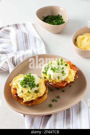 Leckeres herzhaftes Frühstück, Eier Atlantic in einem Teller auf weißem Hintergrund, Runde gebratene Brötchen mit Lachs und Eier Benedikt, Sauce Hollandaise Stockfoto