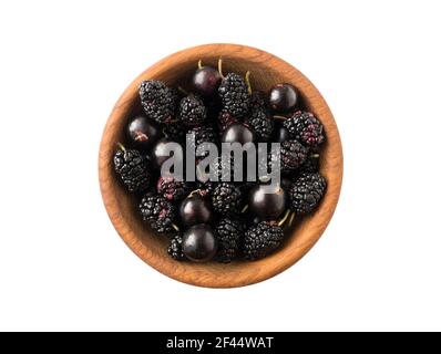 Schwarze Beeren auf Weiß. Schwarze Johannisbeeren und Maulbeeren in einer Holzschale isoliert auf weißem Hintergrund. Schwarze Beeren isolieren. Beeren mit Kopierplatz für Stockfoto