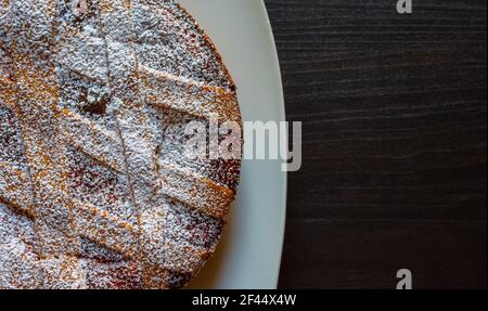 Nahaufnahme der neapolitanischen Pastiera, typisch italienischer Kuchen zu Ostern. Gefüllt mit Ricotta-Käse und kandierten Früchten, bedeckt mit Puderzucker. Stockfoto