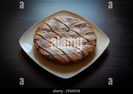 Nahaufnahme der neapolitanischen Pastiera, typisch italienischer Kuchen zu Ostern. Gefüllt mit Ricotta-Käse und kandierten Früchten, bedeckt mit Puderzucker. Stockfoto