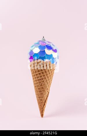 Bunte Weihnachtskugel in lebendigen Farbverlauf holografische Farben mit Eiscreme-Membran. Minimales Urlaubskonzept. Stockfoto