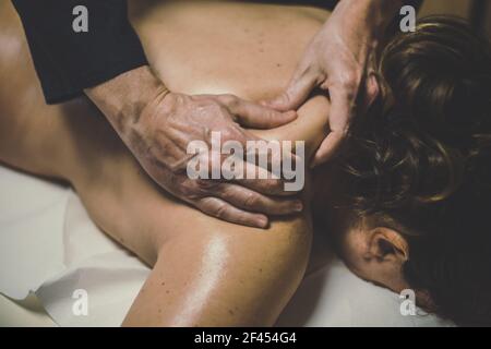 Soft-Fokus-Ansicht des Mannes massiert eine Frau in einem Wellness-Center. Geölte Hände auf einem Körper, der die Muskeln entspannt und Verspannungen löst. Ganzheitliche Übung Stockfoto