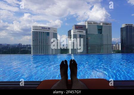 Entspannende Szene eines unendlichen Pools mit dem Hintergrund der Skyline von kuala lumpur. Stockfoto