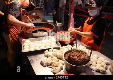 TAIPEI, TAIWAN - 4. DEZEMBER 2018: Verkäufer macht Pfefferstreuer auf dem Raohe Nachtmarkt in Taipei. Nachtmärkte sind ein großer Teil der taiwanesischen Kultur. Stockfoto