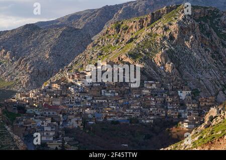 Akre, Irak. März 2021, 18th. Blick auf Häuser, die am Berghang der Altstadt von Akre gebaut wurden.die Stadt Akre im Gouvernement Duhok bereitet sich darauf vor, Nowruz (das persische Neujahr oder das kurdische Neujahr) zu feiern, indem sie Fahnen über den Bergen hängt. Das persische Neujahr oder das Kurdische Neujahr ist eine alte zoroastrische Tradition, die von Iranern und Kurden am 20th. März jedes Jahres gefeiert wird und mit der Frühlingstaquinoktikum zusammenfällt. (Foto: Ismael Adnan/SOPA Images/Sipa USA) Quelle: SIPA USA/Alamy Live News Stockfoto