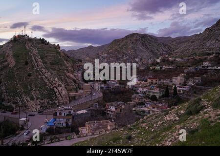 Akre, Irak. März 2021, 18th. Blick auf den Sonnenuntergang über der Altstadt von Akre.die Stadt Akre im Gouvernement Duhok bereitet sich darauf vor, Nowruz (das persische Neujahr oder das kurdische Neujahr) mit Fahnen über den Bergen zu feiern. Das persische Neujahr oder das Kurdische Neujahr ist eine alte zoroastrische Tradition, die von Iranern und Kurden am 20th. März jedes Jahres gefeiert wird und mit der Frühlingstaquinoktikum zusammenfällt. (Foto: Ismael Adnan/SOPA Images/Sipa USA) Quelle: SIPA USA/Alamy Live News Stockfoto