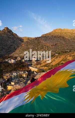 Akre, Irak. März 2021, 18th. Kurden setzen in der Altstadt von Akre eine Flagge Kurdistans über einen der Berge.die Stadt Akre im Gouvernement Duhok bereitet sich darauf vor, Nowruz (das persische Neujahr oder das kurdische Neujahr) zu feiern, indem sie Fahnen über den Bergen aufhängen. Das persische Neujahr oder das Kurdische Neujahr ist eine alte zoroastrische Tradition, die von Iranern und Kurden am 20th. März jedes Jahres gefeiert wird und mit der Frühlingstaquinoktikum zusammenfällt. (Foto: Ismael Adnan/SOPA Images/Sipa USA) Quelle: SIPA USA/Alamy Live News Stockfoto