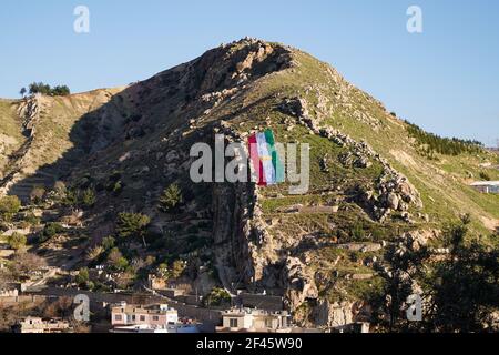 Akre, Irak. März 2021, 18th. Blick auf eine kurdische Flagge auf einem der Berge in der Altstadt von Akre.die Stadt Akre im Gouvernement Duhok bereitet sich darauf vor, Nowruz (das persische Neujahr oder das kurdische Neujahr) zu feiern, indem sie Fahnen über den Bergen aufhängt. Das persische Neujahr oder das Kurdische Neujahr ist eine alte zoroastrische Tradition, die von Iranern und Kurden am 20th. März jedes Jahres gefeiert wird und mit der Frühlingstaquinoktikum zusammenfällt. (Foto: Ismael Adnan/SOPA Images/Sipa USA) Quelle: SIPA USA/Alamy Live News Stockfoto